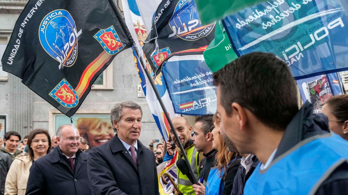El líder del PP, Alberto Núñez Feijóo (c) durante la protesta de agentes de Policía contra la ley de seguridad ciudadana frente a la Cámara Baja, cuyo pleno debate este martes si inicia la tramitación por la vía de urgencia de la reforma de esta ley, conocida como ley mordaza.