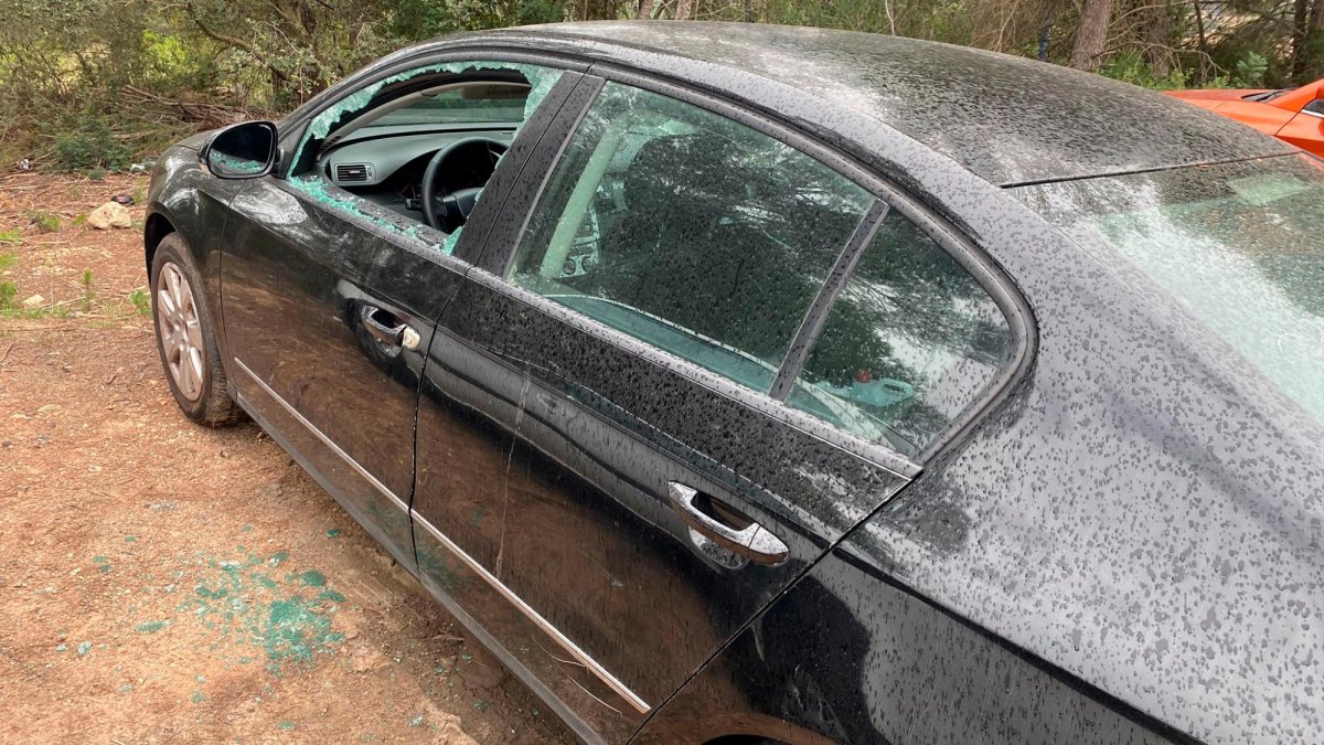Uno de los coches con los vidrios reventados.