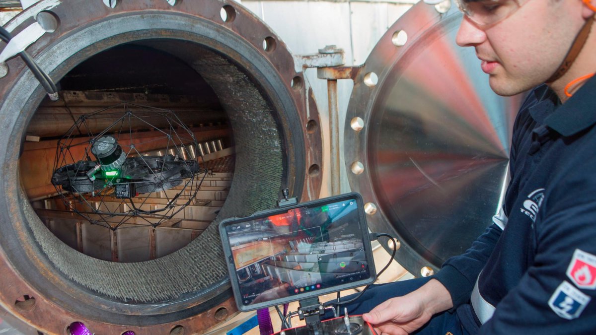 El dron se introduce en uno de los equipos, con el técnico controlándolo en el exterior.