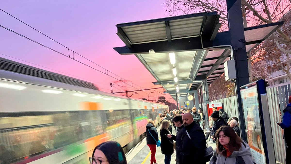 Gente esperando la llegada de trenes en Calafell.