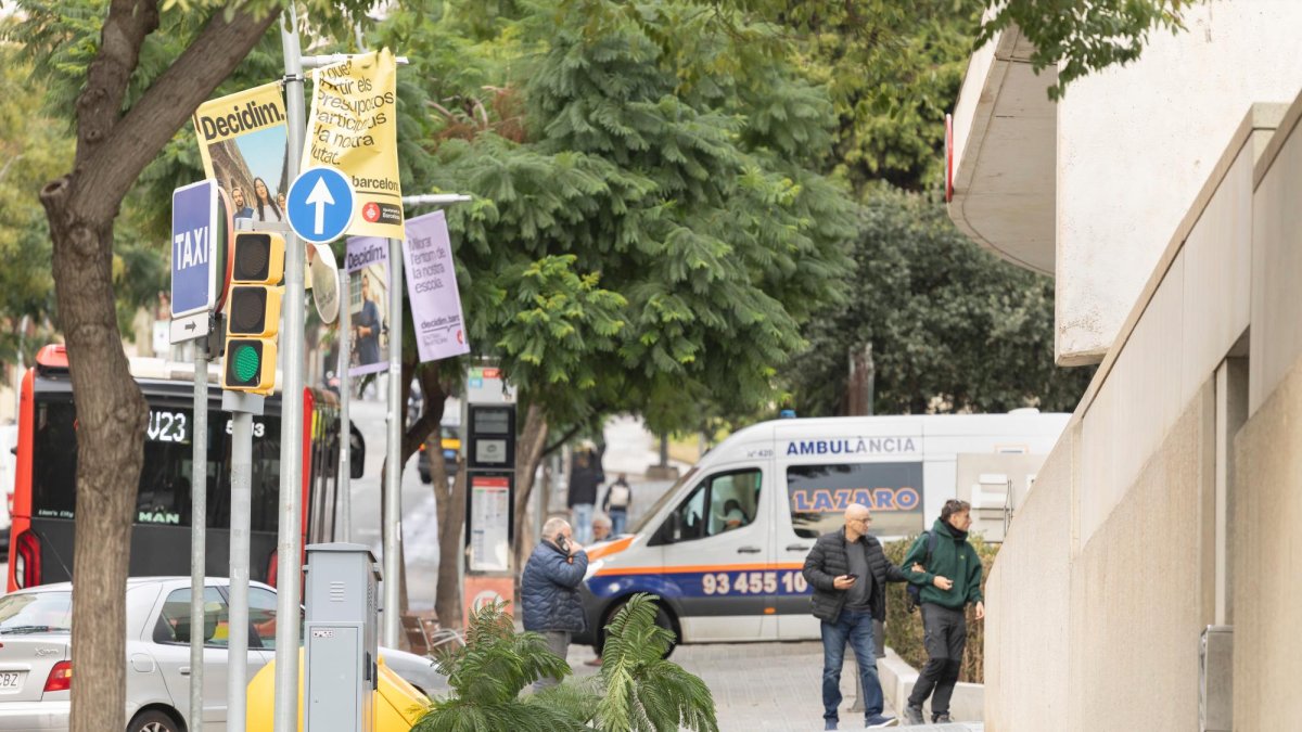 Varias personas caminan por una calle de con una rama de árbol caída , este miércoles en que las fuertes rachas de viento en la ciudad de Barcelona han llegado a los 90km/h en algún punto, y han provocado caídas de árboles y de ramas en la vía pública.