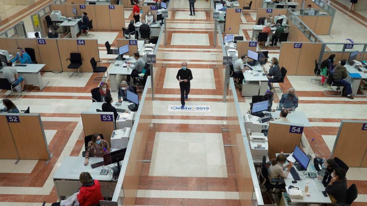 Varias personas son atendidas presencialmente para elaborar el borrador de la renta.