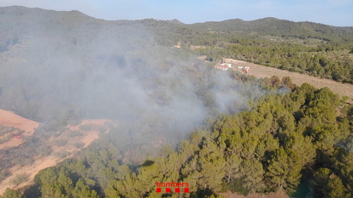 Un bombero apagando el fuego de Maspujols.