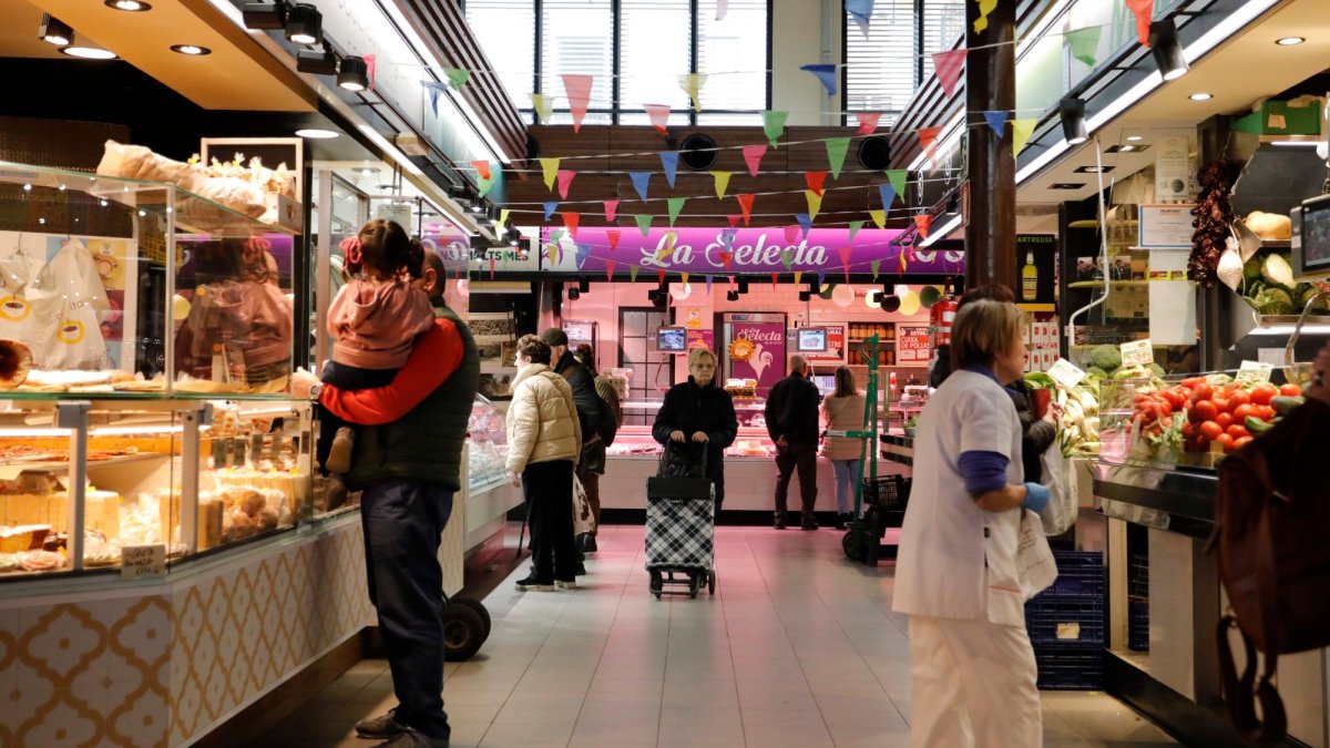 Varios clientes pasean y efectúan sus compras en el Mercat Central de Tarragona.