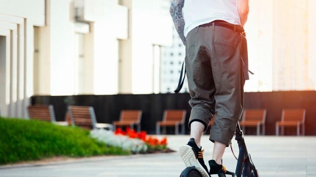 Un hombre a bordo de un patinete.