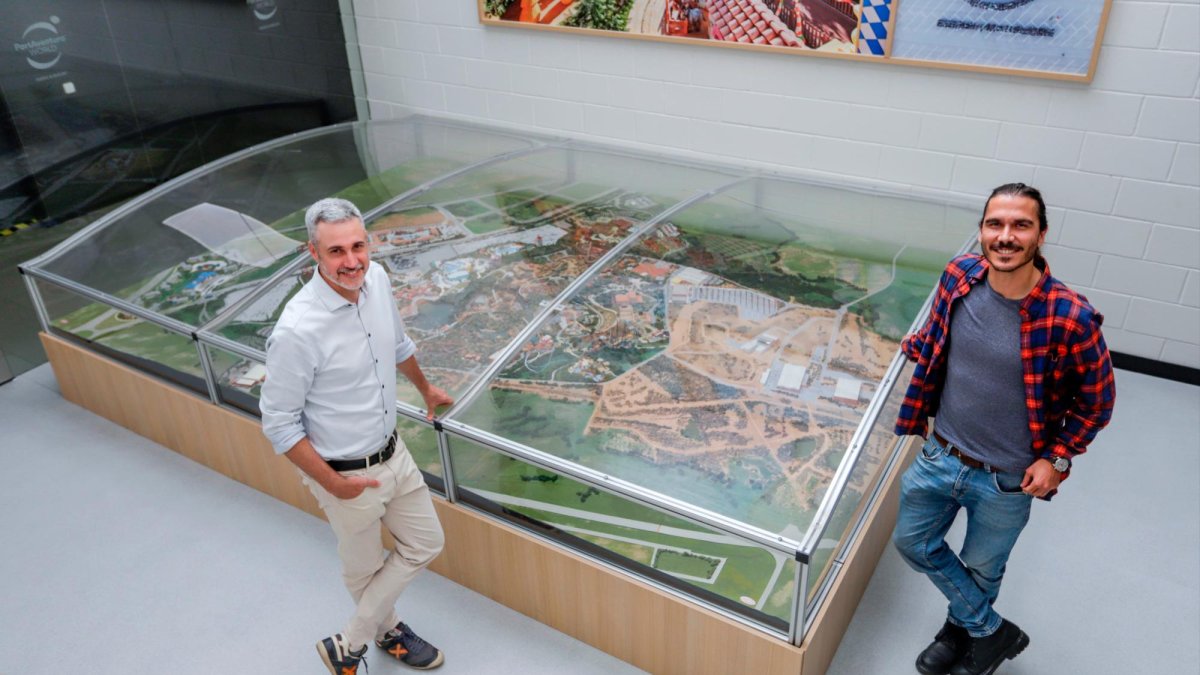 Andreu Tobella y Marc Melús en las instalaciones de PortAventura World con la maqueta del parque temático.