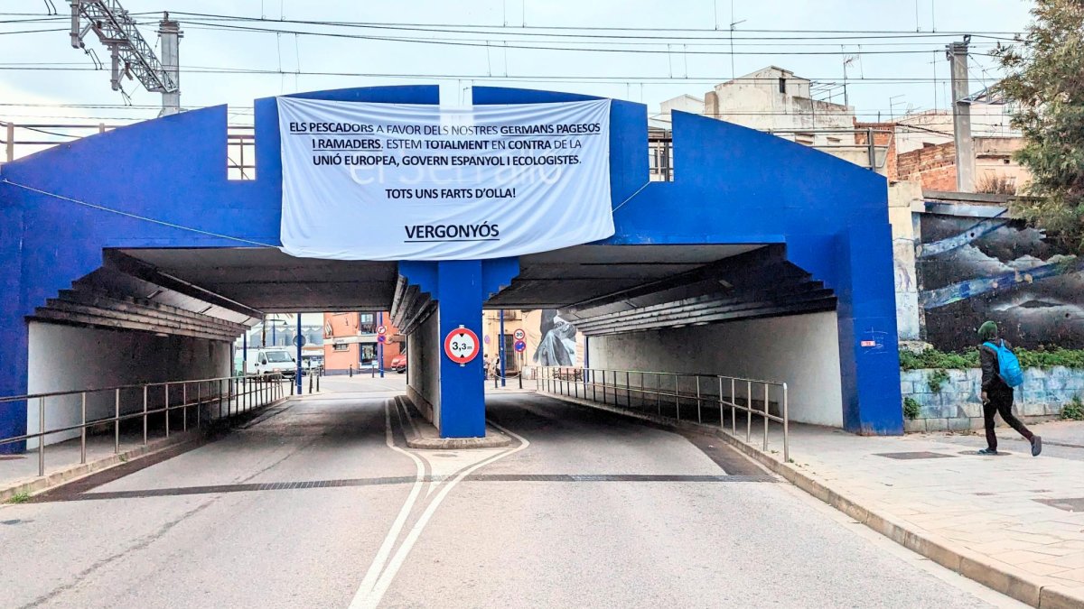La pancarta de apoyo a los payeses está colgada desde hace días en el puente que da acceso al barrio del Serrallo.