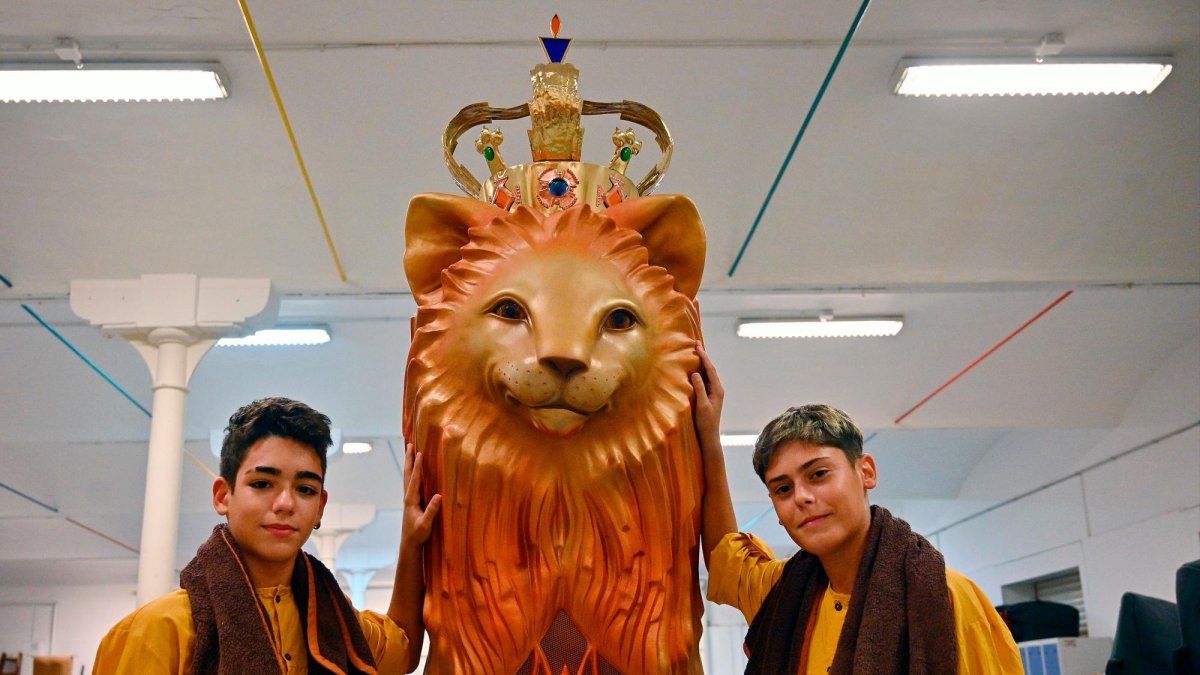 L’Iker Montalbo i en Gibert García, amb la vestimenta festiva i el Lleó Petit darrere.