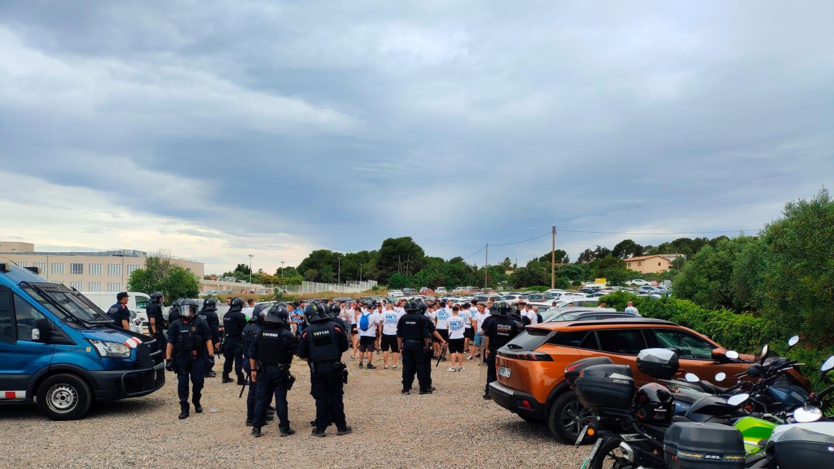 Agentes de los Mossos d’Esquadra, con aficionados del Málaga tras los incidentes.