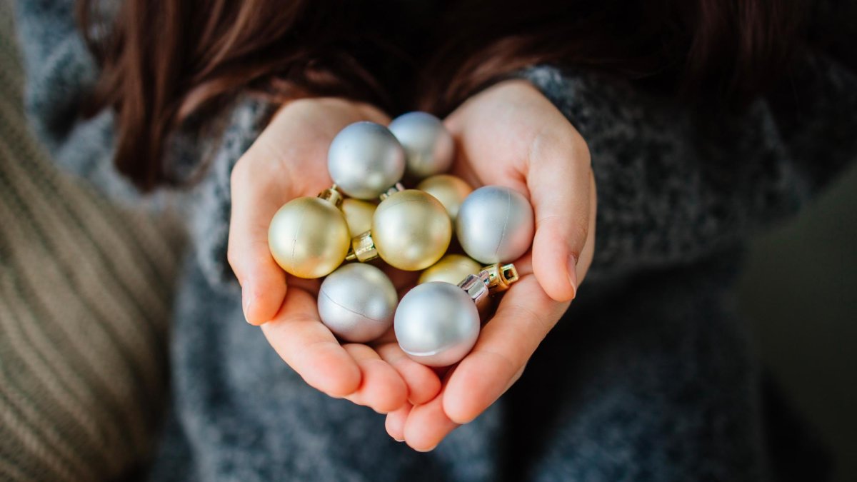 Necesitaréis 2 adornos de Navidad pequeños que quepan cada uno en una mano cerrada.