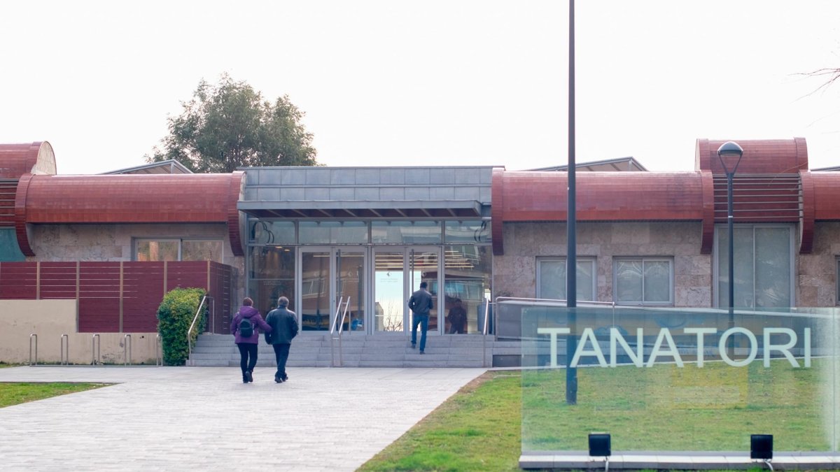 Fachada del tanatorio municipal de Reus, con personas dirigéndose a su interior.