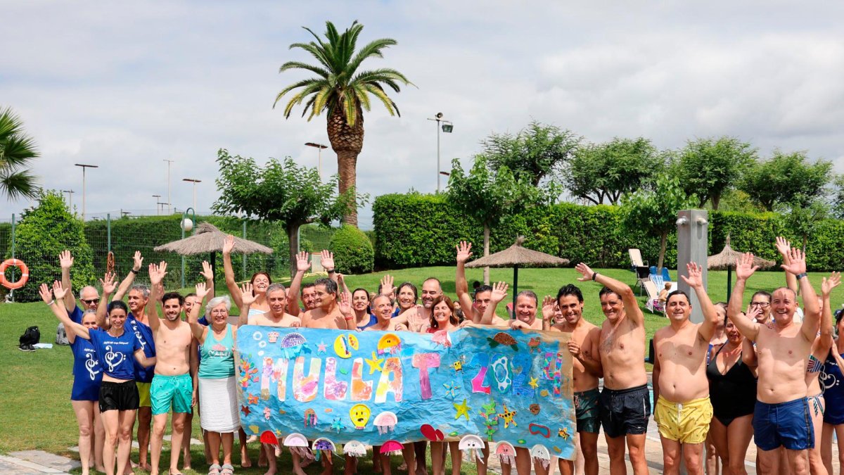 Representantes y participantes en Reus mostrando una pancarta del acto.