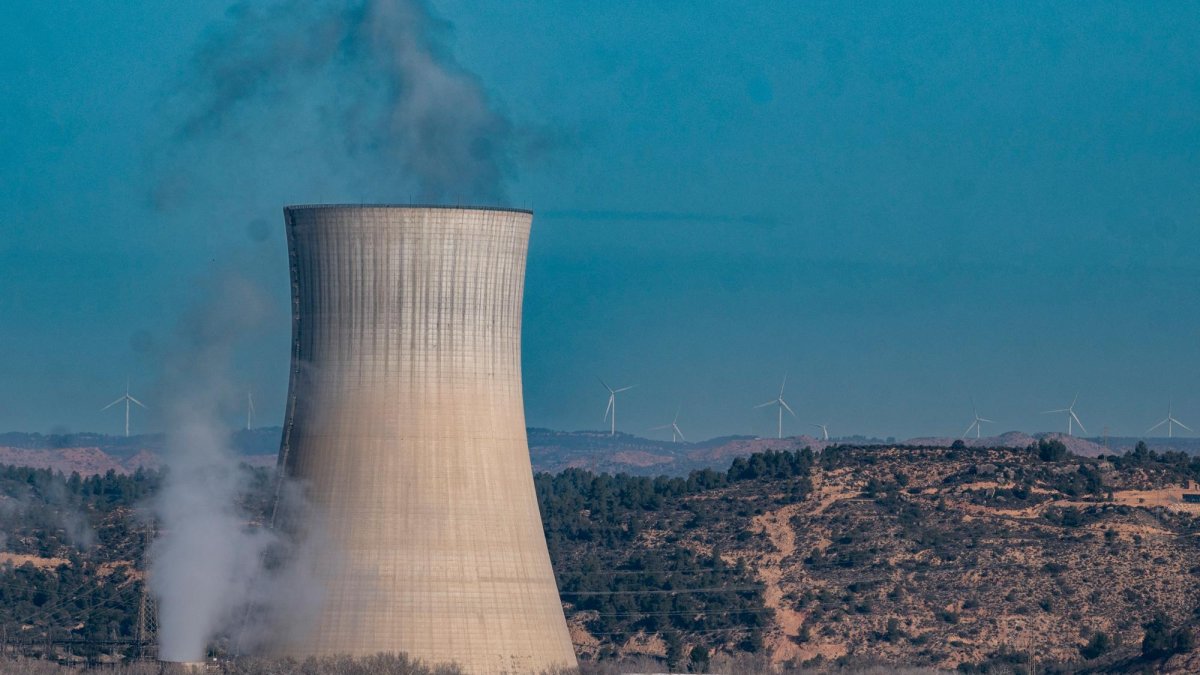 En primer plano, la central nuclear de Ascó, en la Ribera d’Ebre. Al fondo, en el horizonte, algunos molinos eólicos.