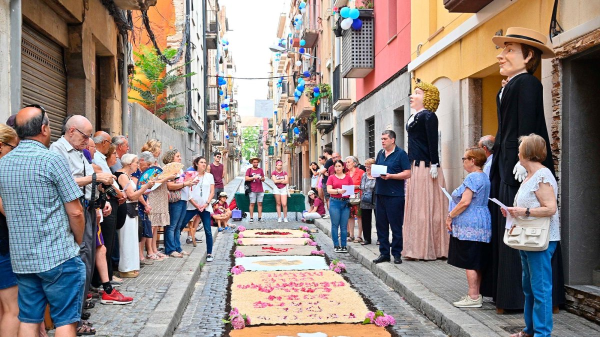 Els veïns del barri del Carme, amb catifes a terra fetes per a l’ocasió, ahir escoltant mossèn Josep M. Gavaldà (a la dreta).