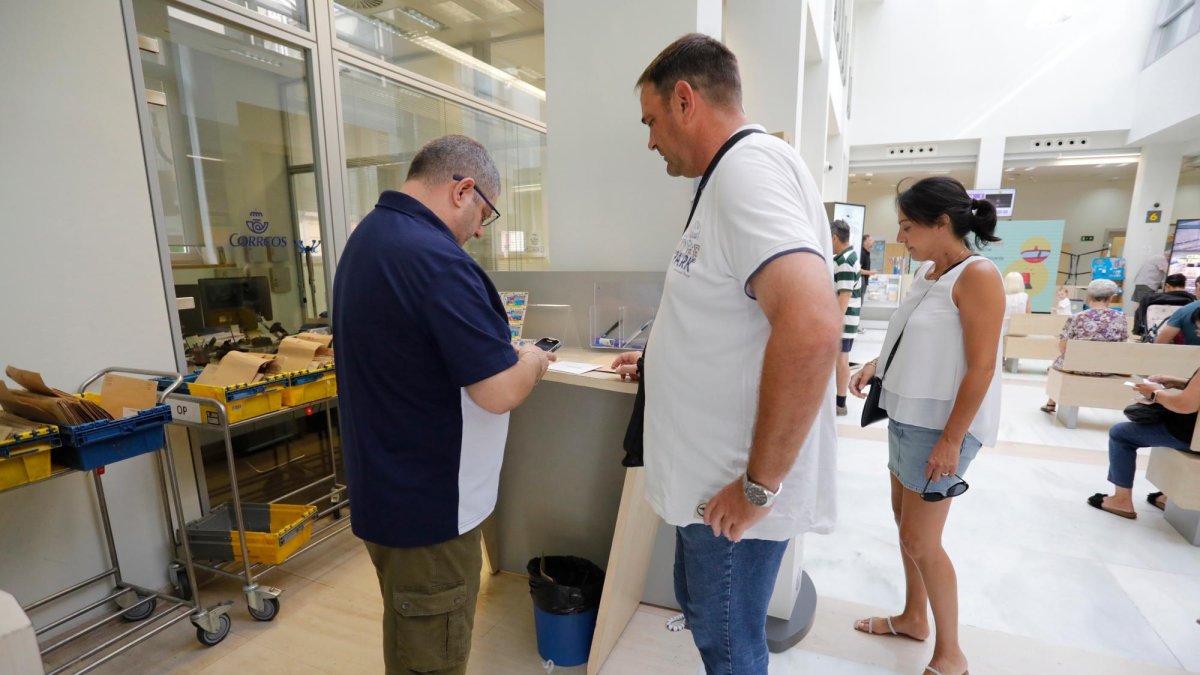 El personal de Correos indicando los pasos a seguir a los votantes.