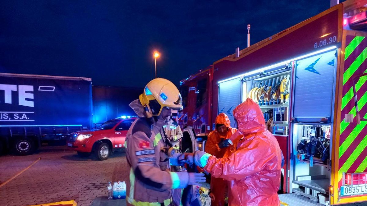 Los bomberos poniéndose el traje de protección química.