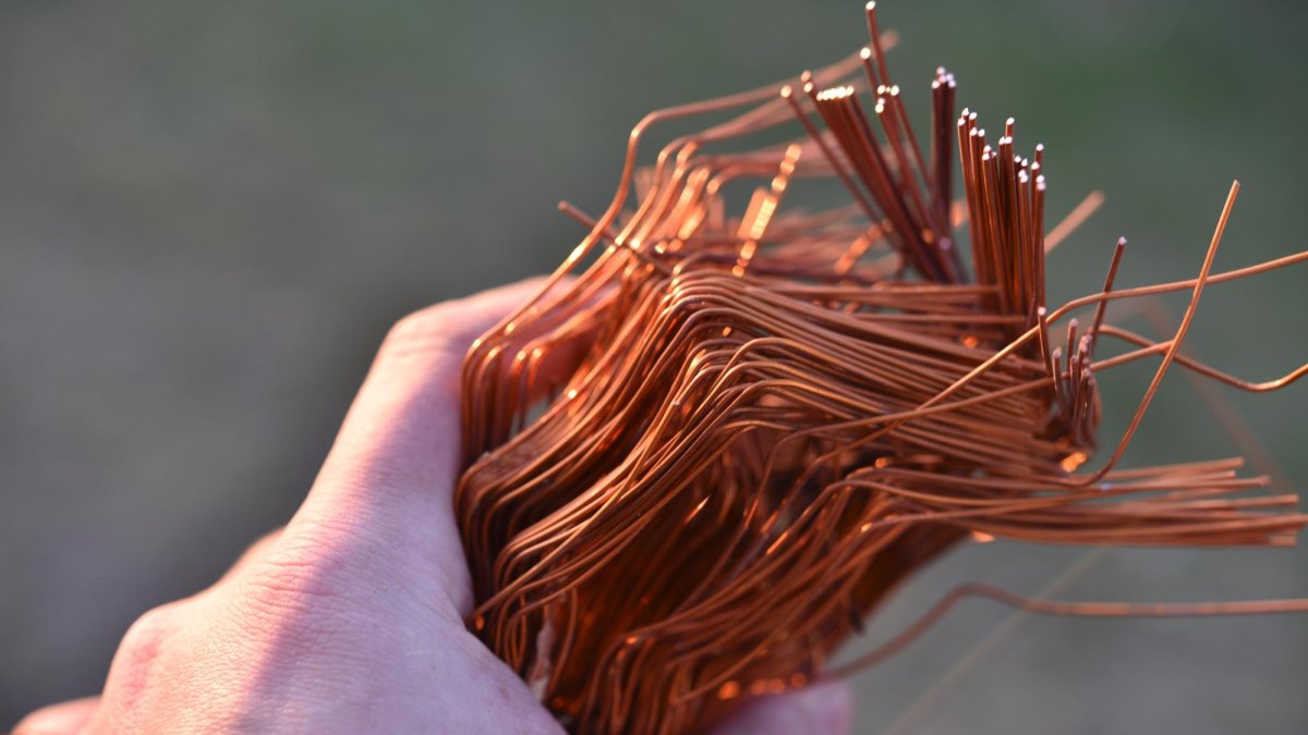 Una persona sostiene un puñado de cable de cobre.