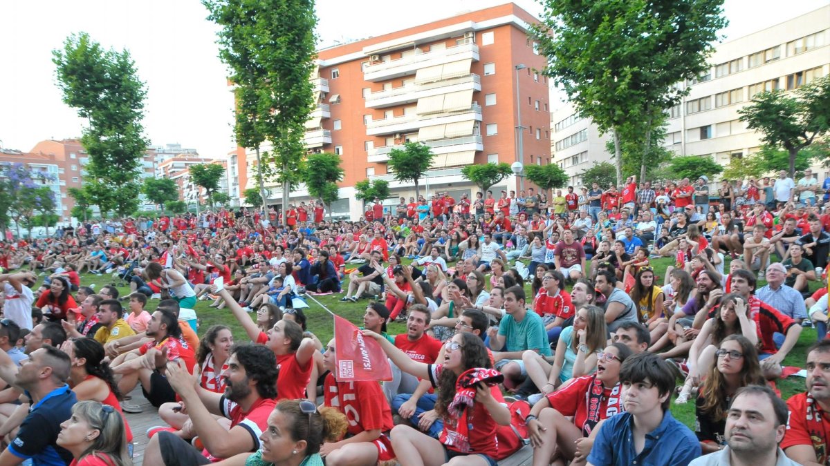 Aficionados asisten a un partido en una pantalla gigante montada delante de la antigua Tabacalera.