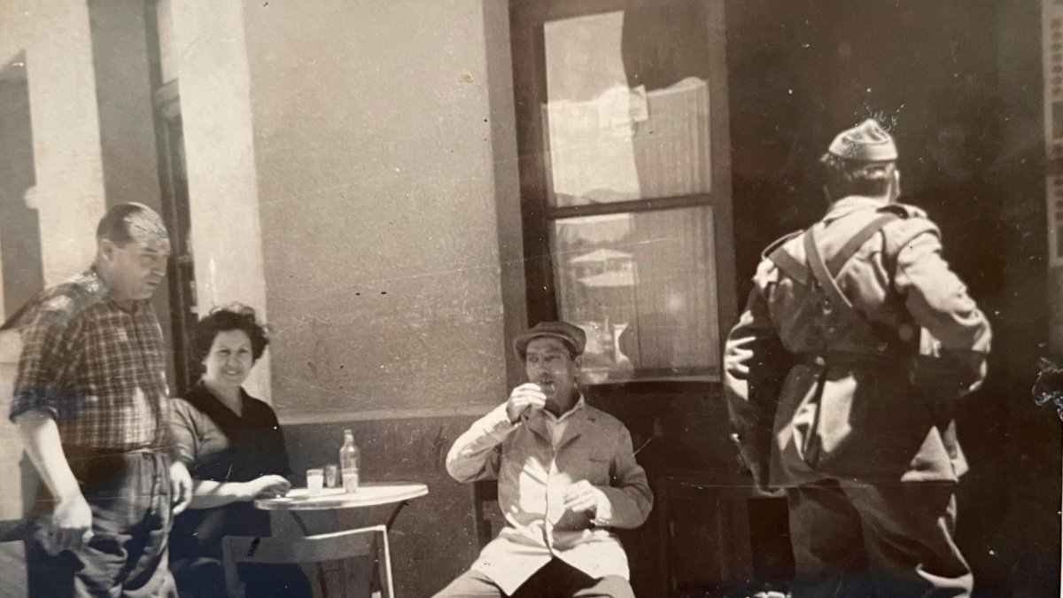 El sereno Pau assegut a l’exterior de Casa Boada, acompanyat de Pilar Cabré i Salvador Boada, amb el sergent Tapias d’esquena.