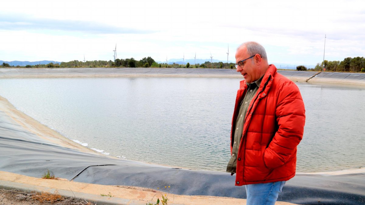 Un trabajador de la comunidad de regantes junto a una balsa en la Fatarella.
