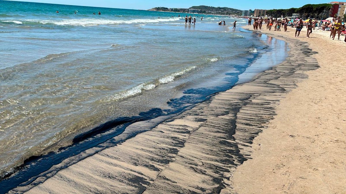 La playa de La Pineda con los restos de carbón.