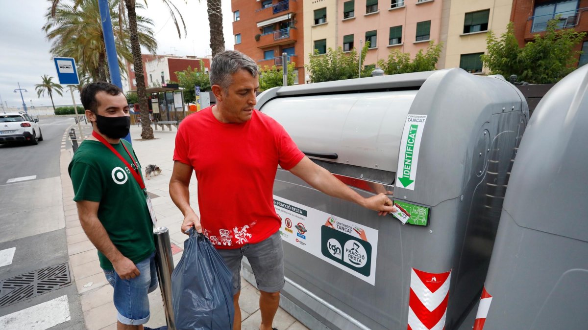 Un vecino de El Serrallo abre un contenedor con una tarjeta durante la prueba piloto que empezó en el año 2021.