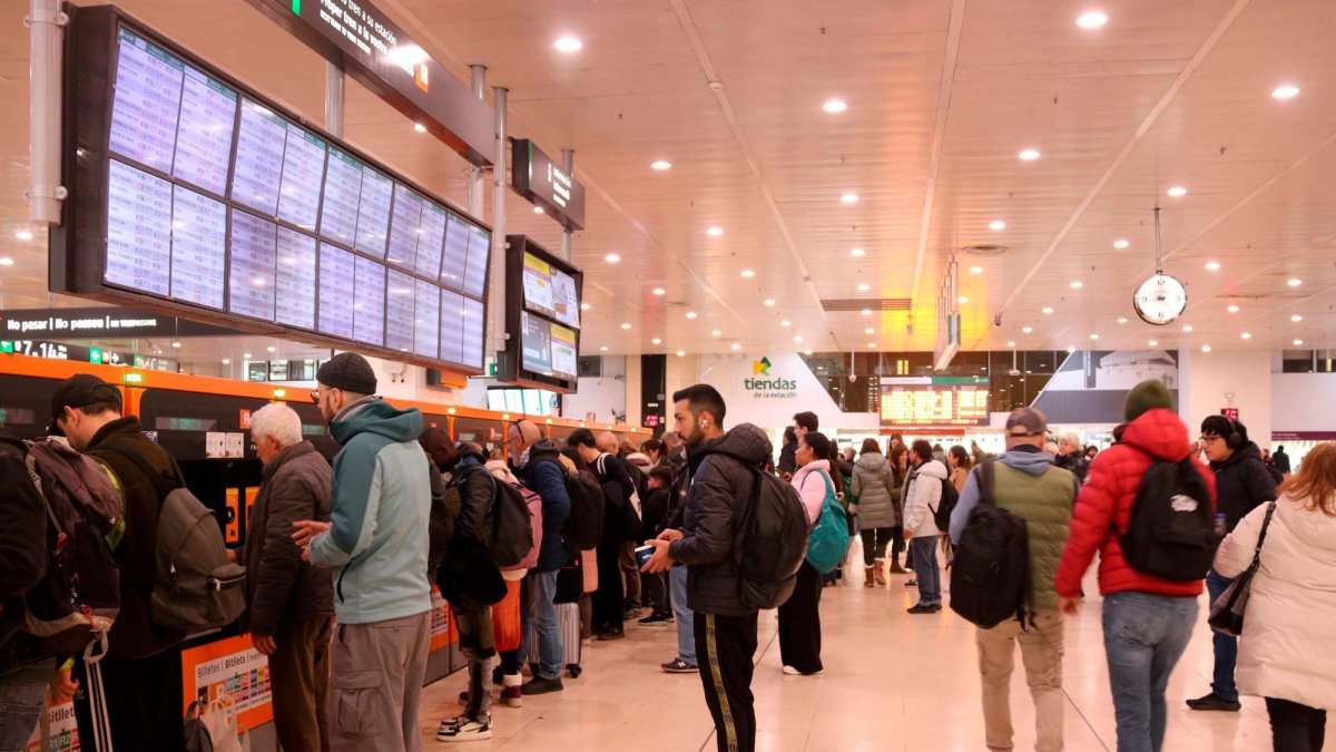 Personas haciendo cola para adquirir títulos de Rodalies en el vestíbulo de la estación de Sants.