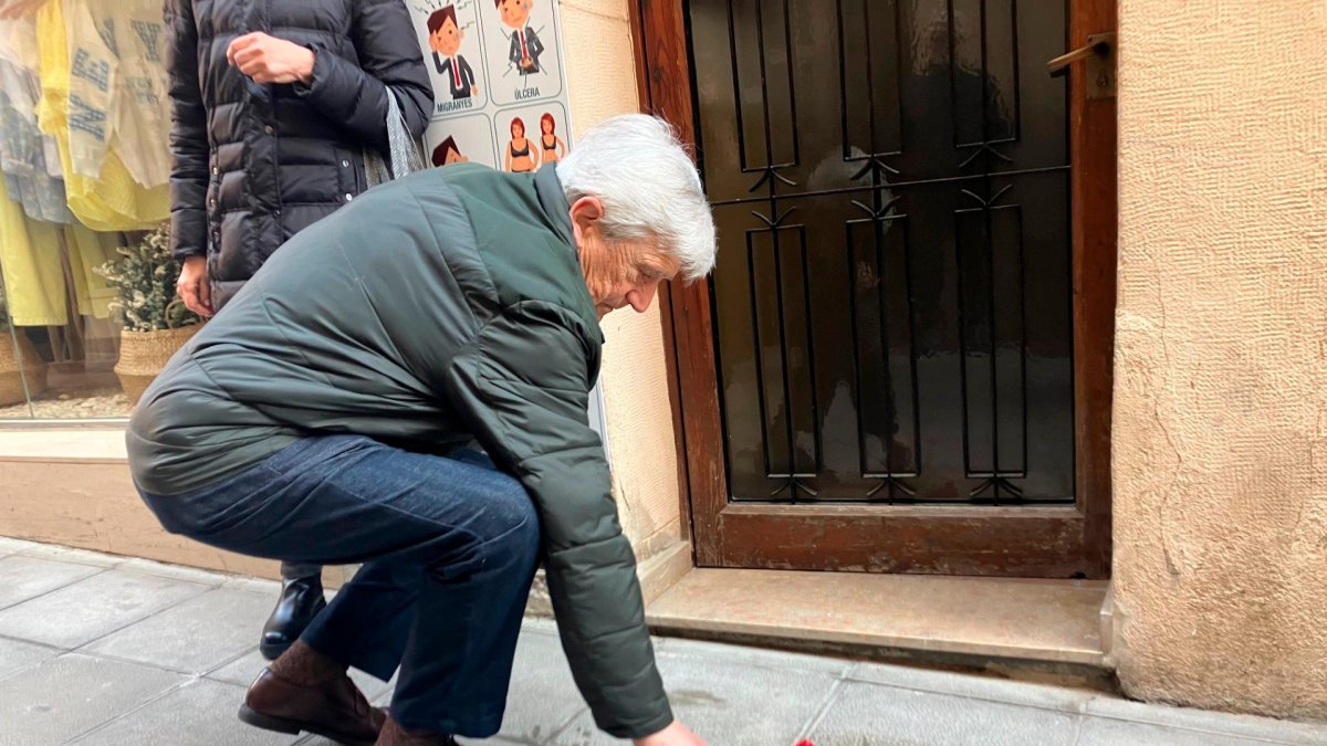 Un familiar deposita una flor junto a la placa.