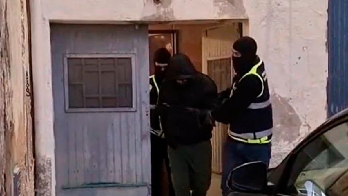 Los dos agentes acompañando a la persona detenida en Tortosa.