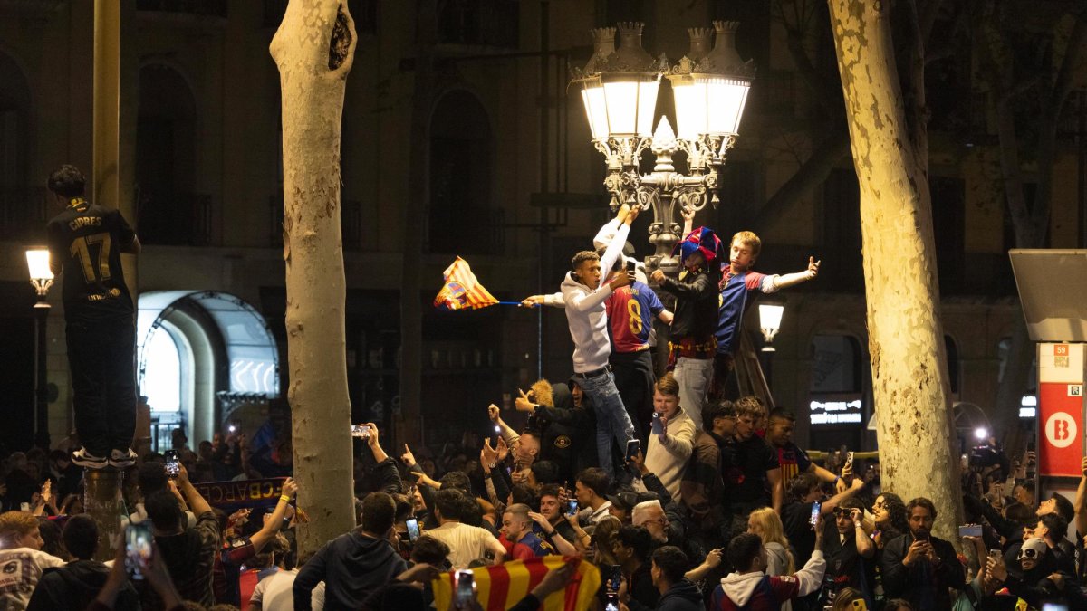 Aficionados del FC Barcelona celebran la victoria de su equipo en la final de la Copa del Rey tras derrotar al Real Madrid.