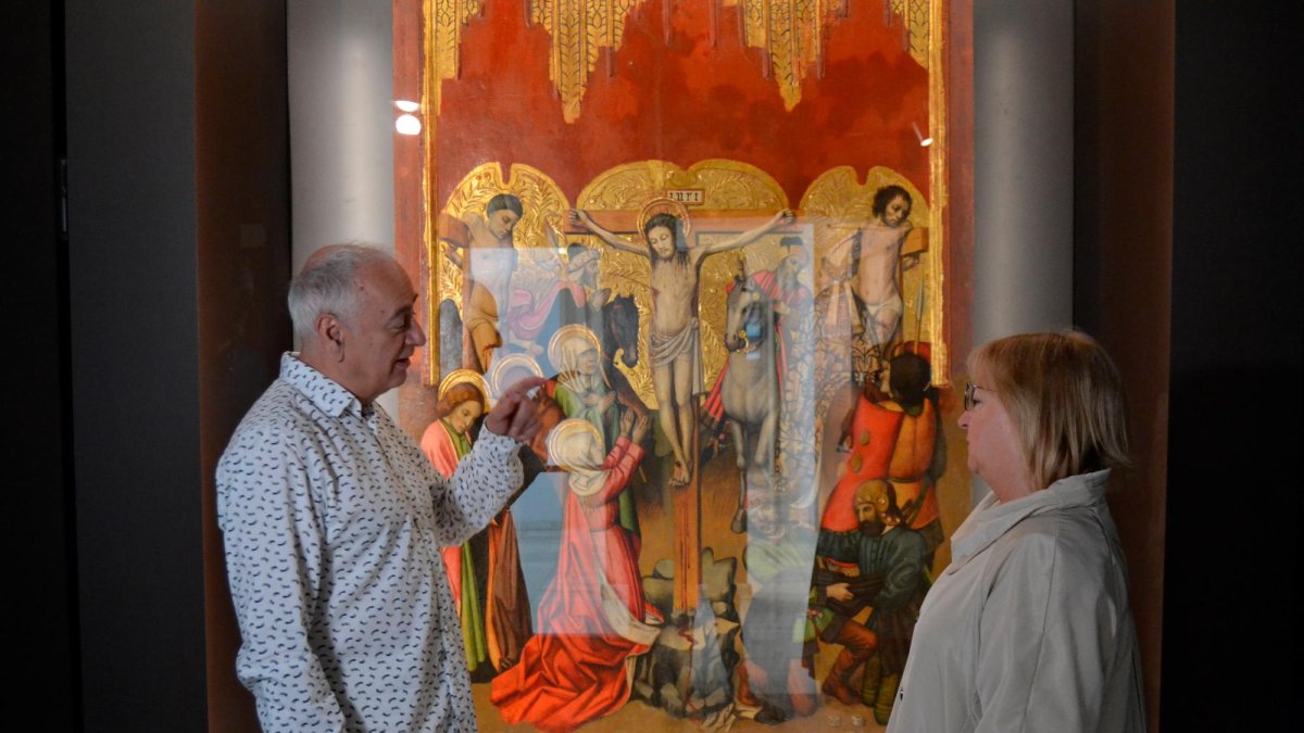 El director del Museu de Valls, Jordi París, i la regidora de Cultura, Rosa Rovira, davant de la taula de la Crucifixió del retaule de Sant Miquel Arcàngel, obra de Jaume Huguet.