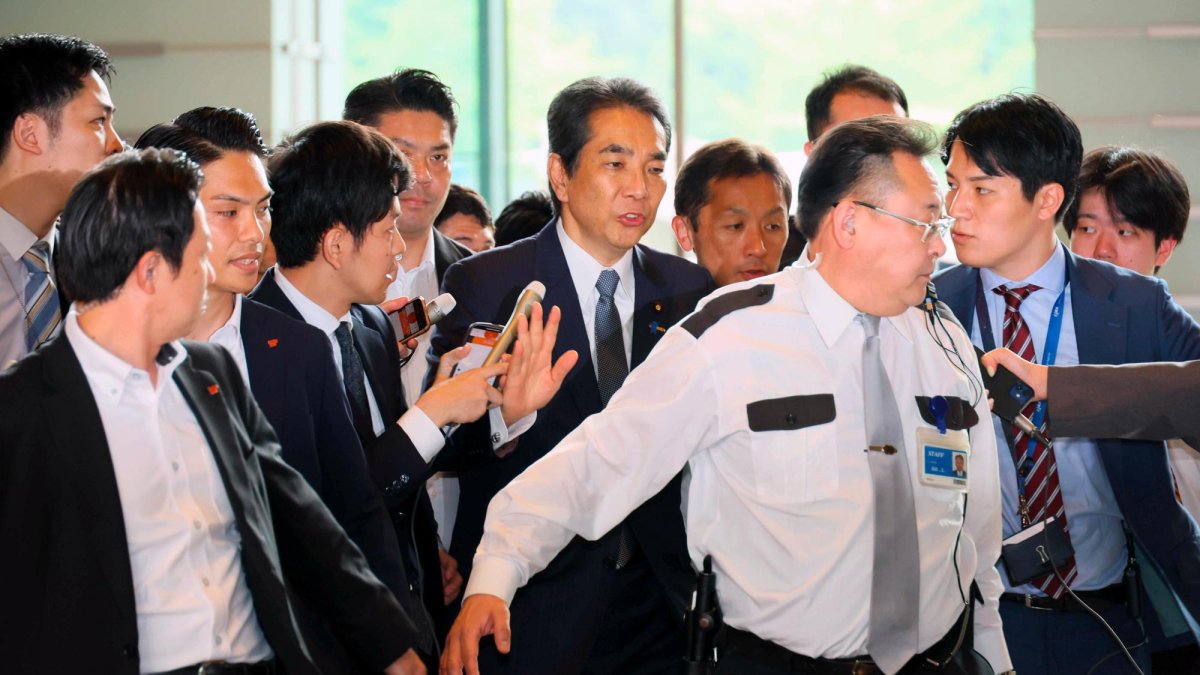 El ministro de Agricultura, Silvicultura y Pesca de Japón, Taku Eto (C), está rodeado de periodistas y agentes de policía a su llegada a la Oficina del Primer Ministro en Tokio, Japón, el 21 de mayo de 2025.