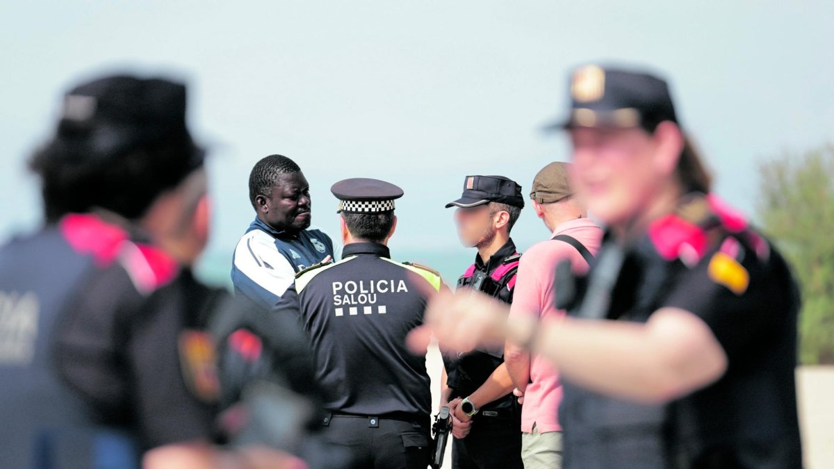 Policías hablando con un mediador de los manteros, este jueves durante la protesta que mantuvo cerrado el paseo Miramar.