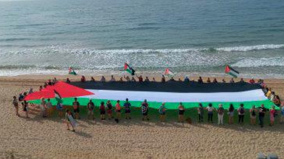 La bandera Palestina desplegada en la playa del Miracle de Tarragona.