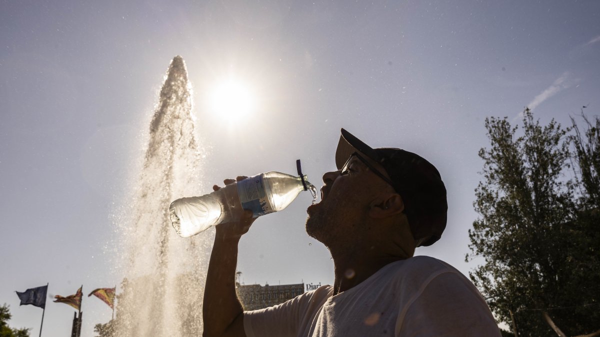 Un hombre bebe agua en la plaza Imperial Tarraco para hidrarse ante las altas temperaturas.