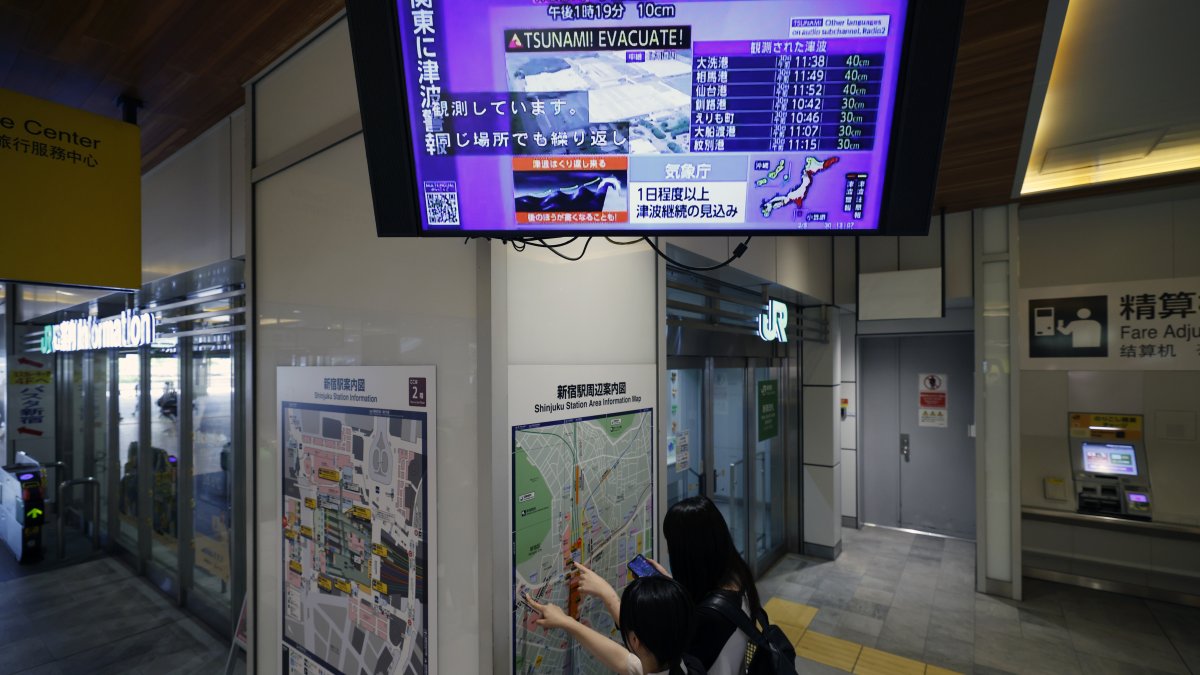 Una televisión muestra los efectos del tsunami.