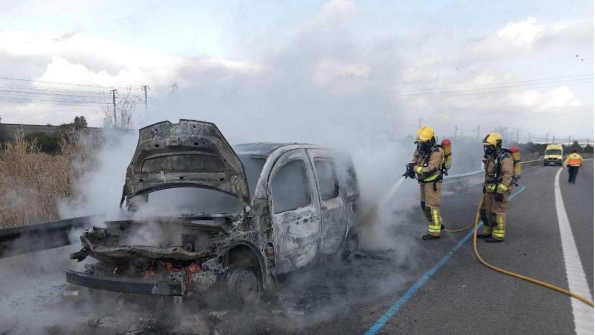 Imagen de archivo de un coche incendiado en la autopista y apagado por Bombers.