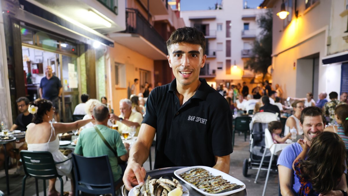 Un camarero muestra algunos de los platos de Bar Sport.