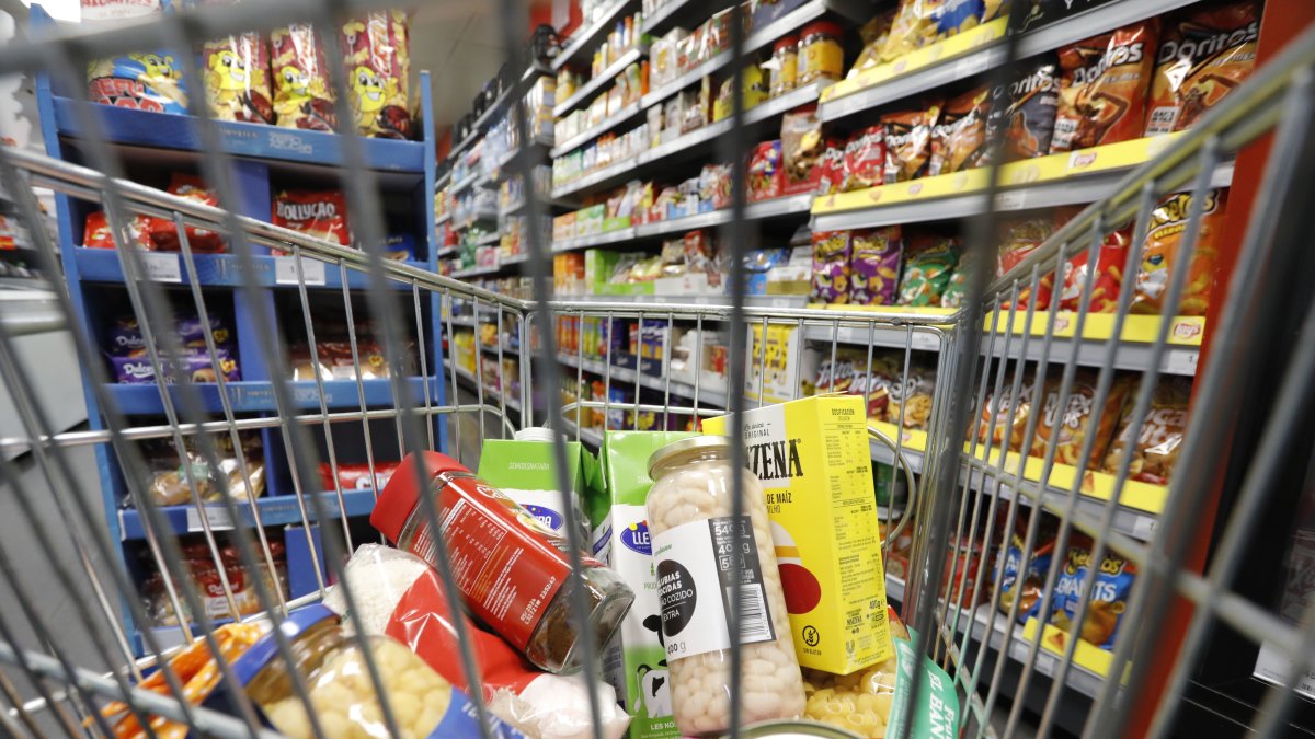 Fotografía de archivo de una cesta de la compra con varios productos en un supermercado de Tarragona.