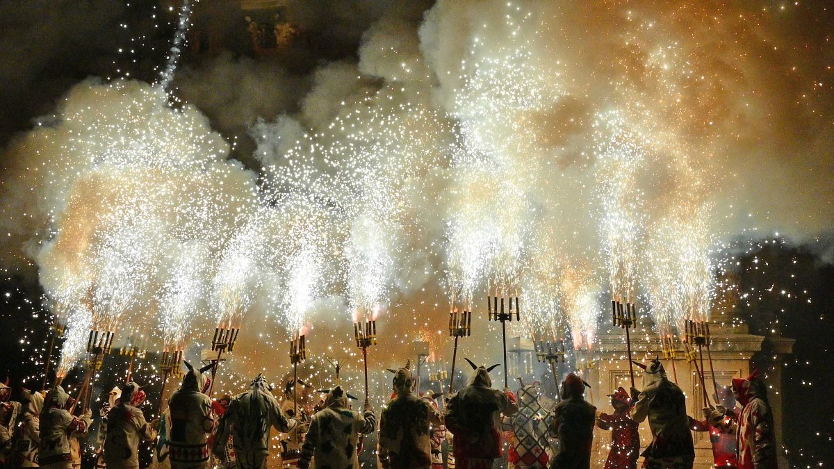 Els Diables aixequen les forques carregades davant la façana del Santuari de Misericòrdia.