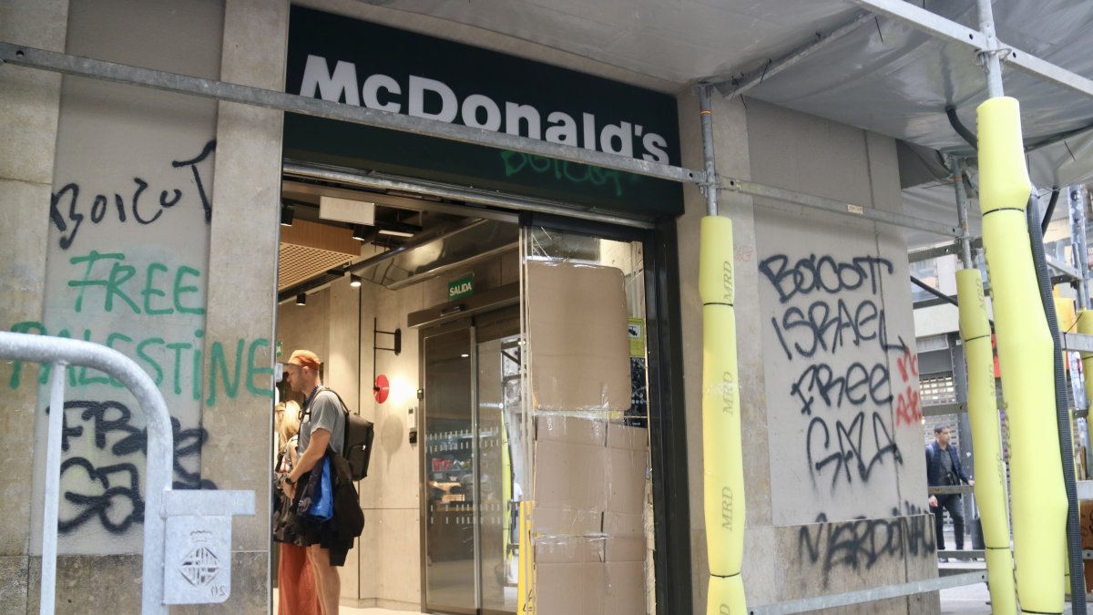 Cartones para cubrir los cristales rotos de la puerta de un establecimiento de comida rápida en La Rambla, Barcelona