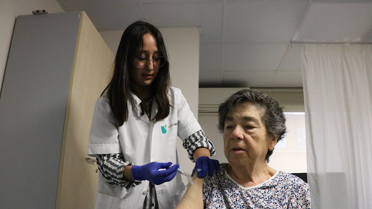 Una profesional del CAP Les Corts, vacunando a una paciente de la gripe y la covid