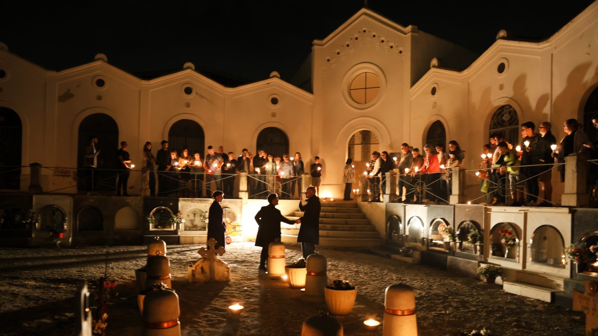 Unes 40 persones recorren el cementiri, amb espelmes a la mà, en cada torn.