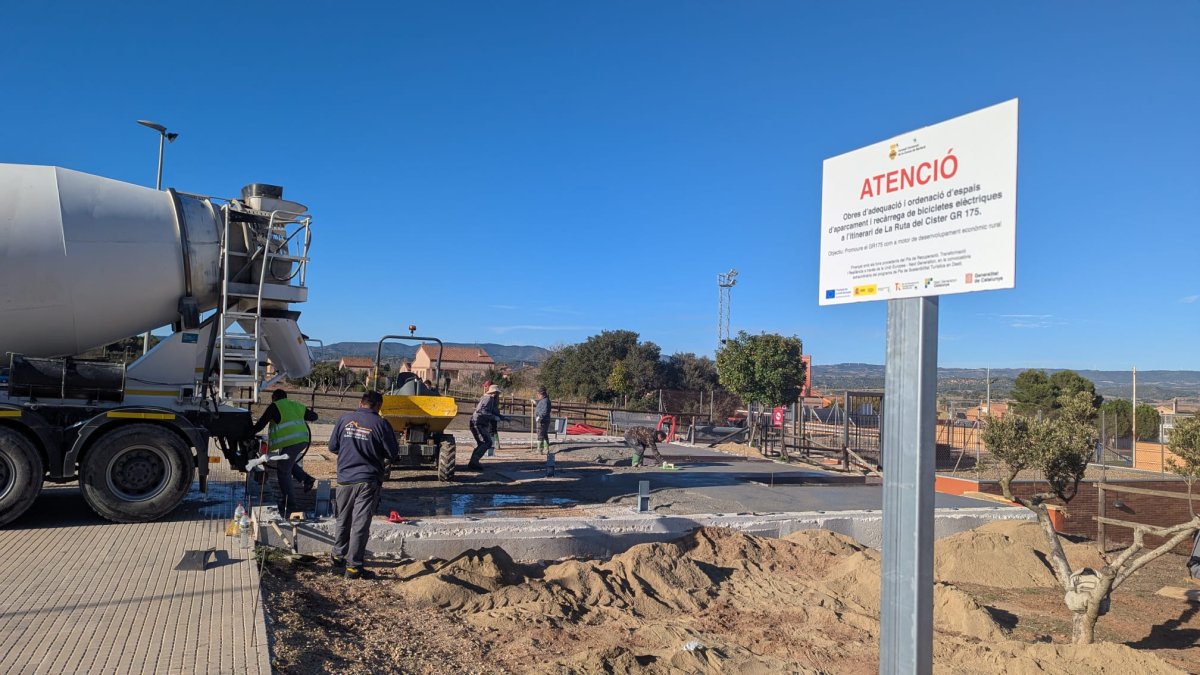Operaris treballant en les obres de la futura estació i recàrrega per a bicis elèctriques de Montblanc, dins de La Ruta del Cister.