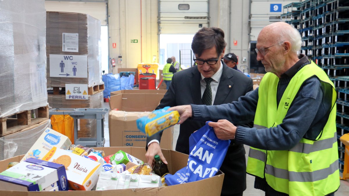 El president de la Generalitat, Salvador Illa, vacía su bolsa de alimentos con productos para el Banc d'Aliments.
