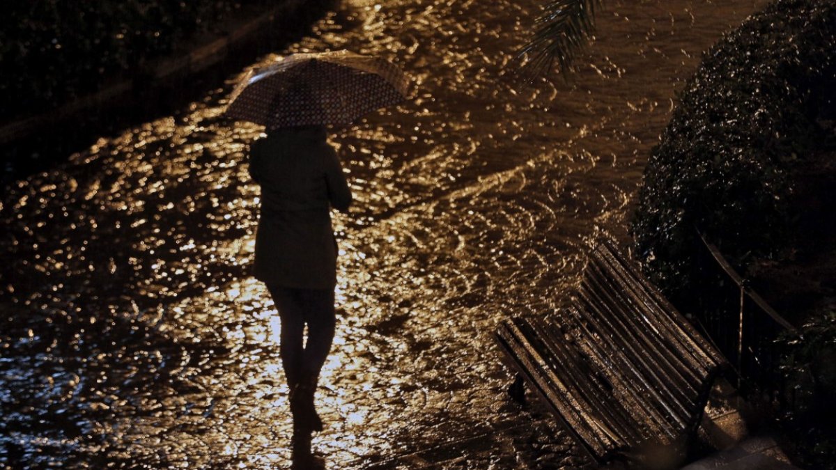Imagen de archivo de una mujer caminando sola de noche
