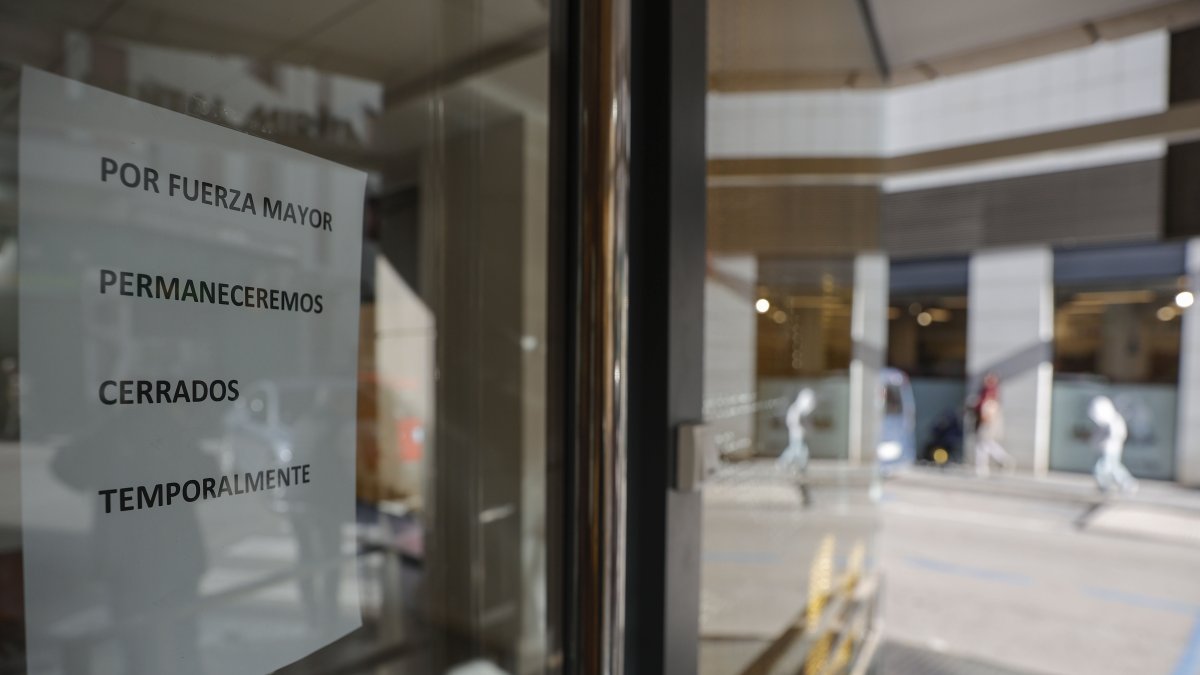 Cartel que indica el cierre temporal en la fachada principal de la clínica dental de Alzira.