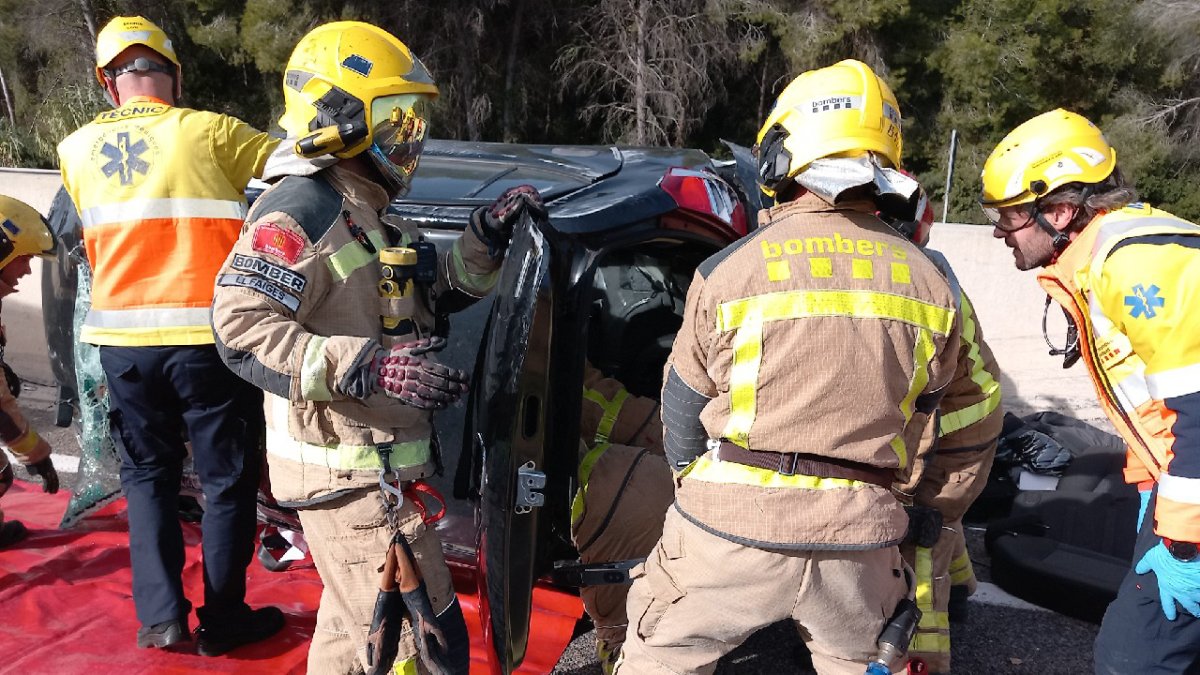 Los bomberos trabajando para sacar del coche a los atrapados.