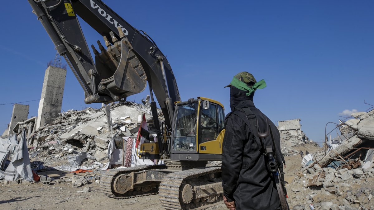 Combatientes de las Brigadas Al Qassam, el ala militar del movimiento Hamás, hacen guardia mientras buscan los cuerpos de rehenes israelíes.