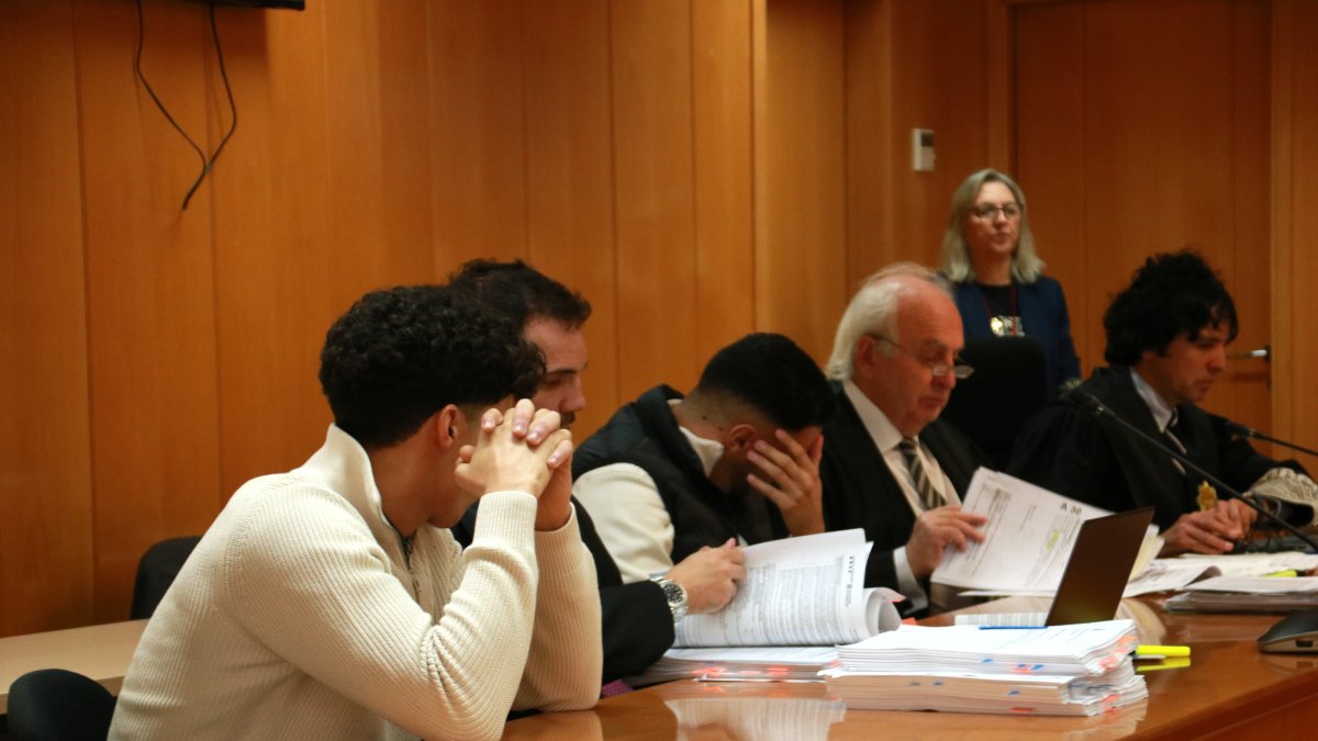 Dos de los cinco hombres acusados de varios delitos, entre ellos homicidio en grado de tentativa, y sus abogados, al inicio del juicio que se celebra en la Audiencia de Tarragona
